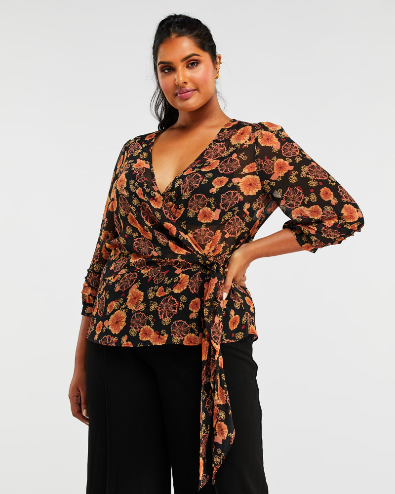 Front of a model wearing a size 1X Golden Blooms Top in Print by Estelle. | dia_product_style_image_id:287489